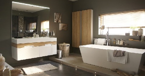 Une salle de bain couleur chocolat design avec un meuble suspendu et une baignoire îlot blanche très tendance et moderne.