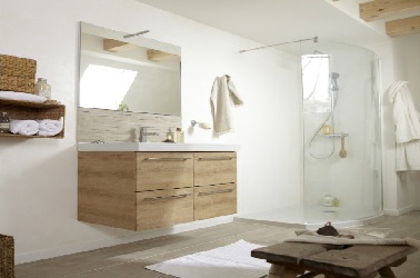Ambiance salle de bain zen design avec des meubles en bois, un sol en pvc imitation parquet et du blanc très lumineux autour de la douche en verre.