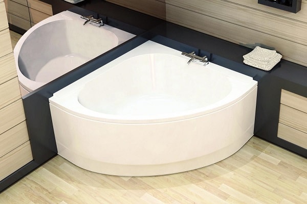 Une baignoire d'angle compacte arrondie pour une petite salle de bain.
