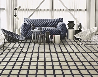 Carreaux de ciment noirs et blancs dans le salon chez Bisazza Pour donner du style à un salon, poser des carreaux de ciment avec des lignes droites noires et blanches c'est hyper esthétique et tendance en matière de déco.