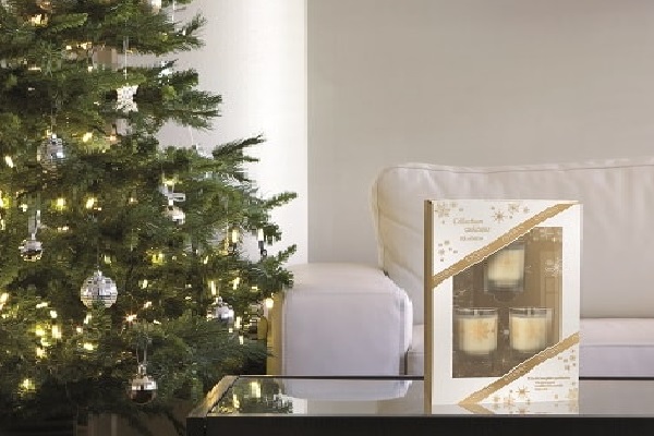 Un cadeau de Noël coffret avec des bougies décoratives et du thé gourmand.