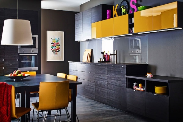 Une cuisine peps et moderne avec des meubles bois noirs et un élément linéaire à la façade jaune moutarde laquée.