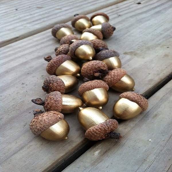 Des glands naturels peints en dorés pour créer une guirlande déco Noël canon.