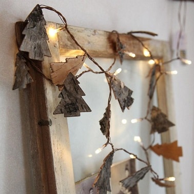 Guirlande lumineuse avec déco sapin de Noël en bois par La Redoute Naturelle, cette guirlande lumineuse est ornée à côté des ampoules LED de petits sapins en bois découpés finement pour une décoration de Noël épurée et nature comme jamais.
