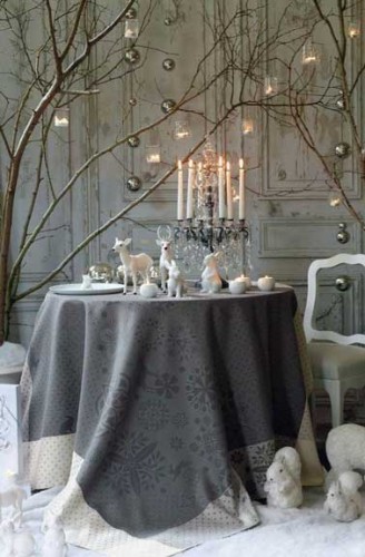 Une belle table de Noël en gris et blanc Idées déco pour table de Noël ambiance boudoir chic décoration grise et blanche avec chandelier linge de table soyeux agrémenté d’animaux de la fôret décoratifs