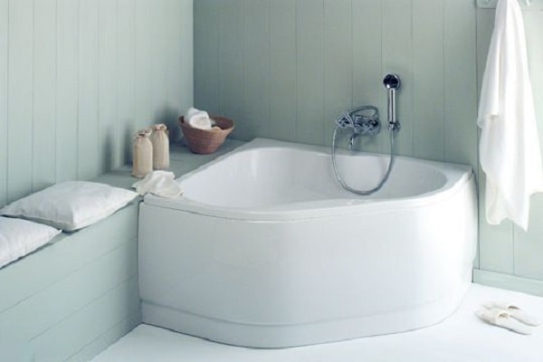 Une baignoire d'angle sabot pour une salle de bain exiguë.