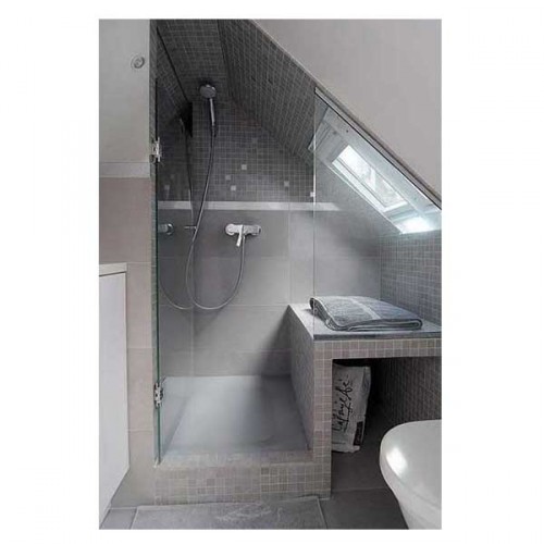 installée sous la pente du toit la douche et le plan recouvert de carrelage gris font de cette petite salle de bain un espace avec WC bien pratique