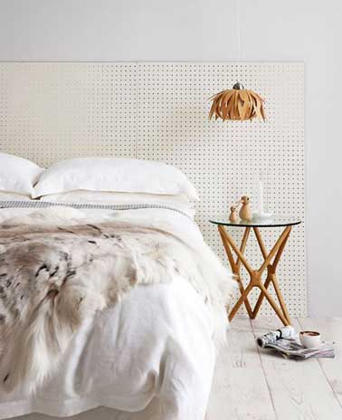 dans une chambre blanche déco scandinave, une tête de lit originale faite avec des plaques d'Isorel peintes en blanc