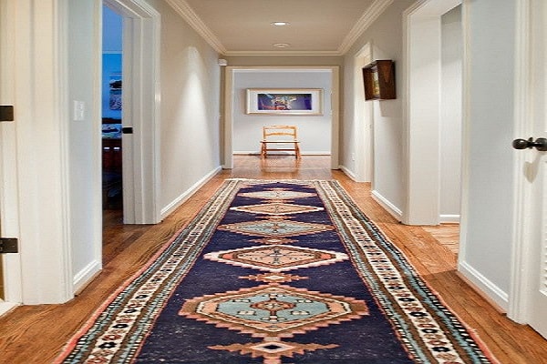 Un grand tapis coloré dans une déco couloir simple.