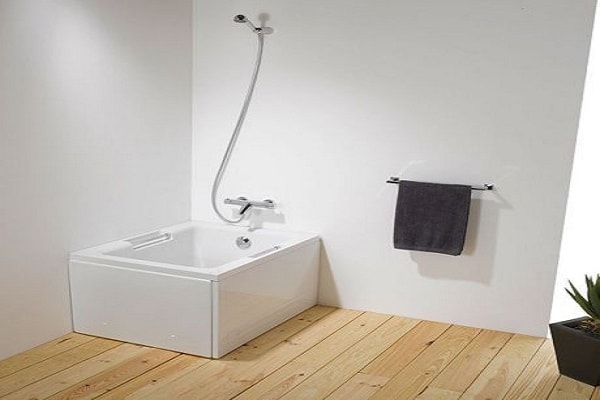 Une baignoire sabot carré discrète dans la salle d'eau.