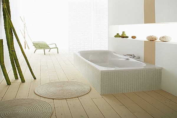 Une baignoire sabot avec un revêtement en faïence dans une salle de bain zen.