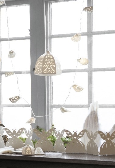 Comme de la dentelle, cette guirlande lumineuse illumine la déco de Noël qui orne ce bord de fenêtre. Associée à une lanterne suspendue, cette guirlande charmante est top.