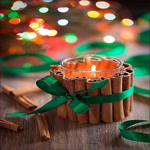 Pour décorer un photophore simple et faire émaner une bonne odeur dans la maison, on entoure le photophore de petits bâtons de cannelle.
