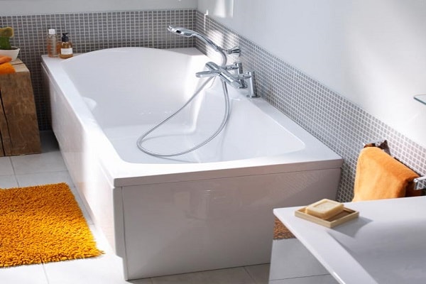 Une baignoire avec repose tête confort dans une salle d'eau minuscule.