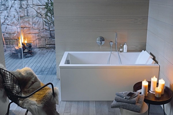 Une jolie baignoire détente petite dans une salle de bain cocooning.