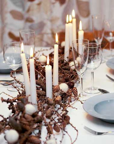 Spectaculaire ce centre de table ajoute une touche nordique sur la table de Noël. Déco bougies cierges blanches et vaisselle pastel sur une nappe blanche.