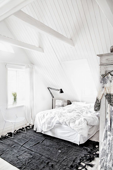Un petit espace idéal pour se relaxer et se reposer, on craque pour cette chambre aménagée sous les combles à la déco toute blanche et au tapis gris anthracite.