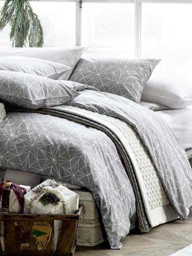 Pensez au linge de lit pour faire la déco cocooning de la chambre. Ici, une couette H&M Home à motifs géométriques dans des nuances douces est assortie aux couleurs de la chambre