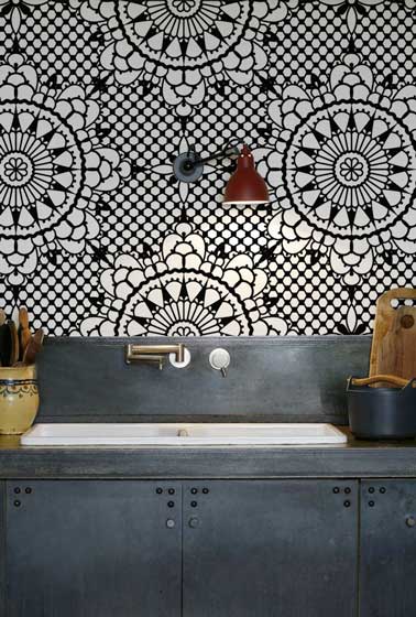 Crédence cuisine réalisée avec un papier peint à motifs inspiration vitrail. Ce papier peint lessivable d’inspiration mauresque réchauffe l'ambiance déco industrielle de cette petite cuisine