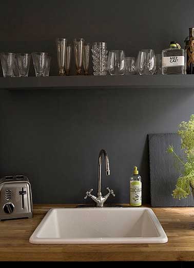 Déco luxueuse pour la crédence en peinture noir mat de cette cuisine contemporaine. Verres et objets inox apportent lumière et intensité à la couleur noir.