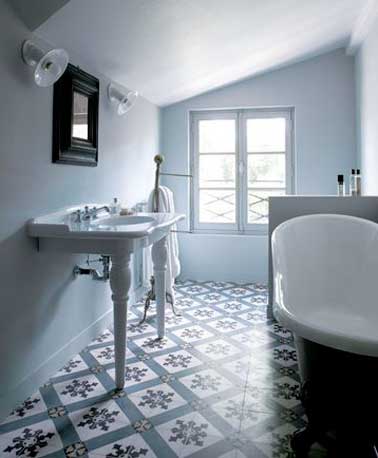 Les carreaux de ciment vintage de cette salle de bain sous les combles se marient parfaitement à la teinte bleu pastel des murs et à la porcelaine blanche.