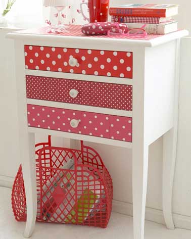 Des chutes de papier peint aux motifs colorés rouges dynamisent cette commode en bois. Un DIY récup facile à faire pour donner de la vie à un vieux meuble
