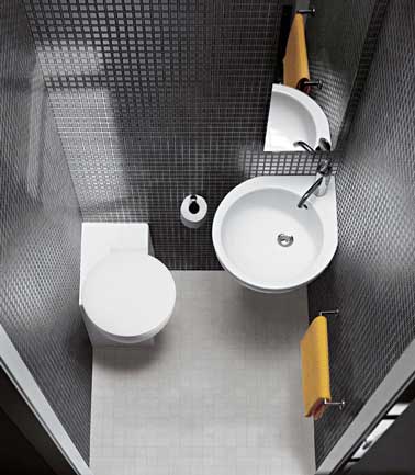 Tendance graphique en noir et blanc pour la déco de ces minis WC. Murs en carrelage noir pour la , lavabo en coin et miroir suspendu pour gagner de la place. 