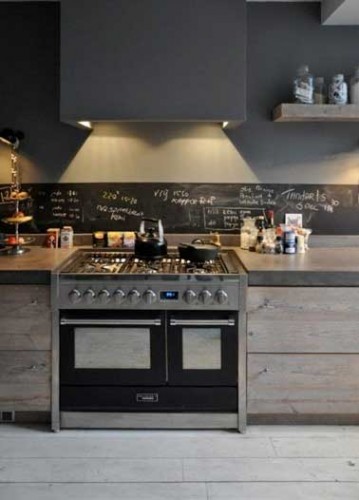 Déco industrielle pour la peinture gris anthracite de la cuisine ouverte. Crédence en pierre grise avec parquet et meubles de rangement en bois non traité.