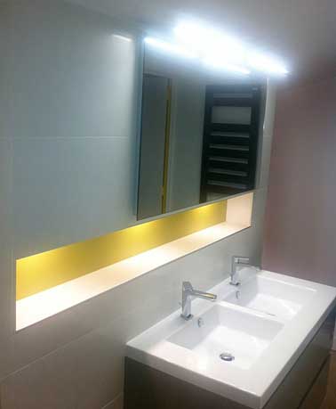 Le jaune peint en bande de couleur ajoute de la profondeur dans la salle de bain. Placée sous une source lumineuse, le ton jaune éclaire une petite pièce. 