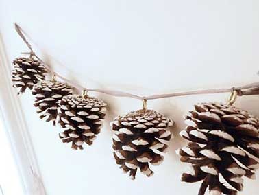 Confectionner$z une jolie guirlande de Noël pour les fêtes en utilisant simplement des pommes de pins, bombez-les de neige artificielle et le tour est jouée ! Idéal pour décorer votre sapin ou votre table de Noël.