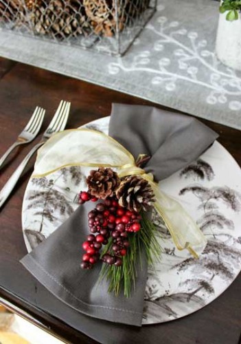 Complètement british cette déco de table de Noël joue avec les camaïeux de couleurs grise. Serviettes en toile de Jouy, branche de houx rouge et ruban jaune
