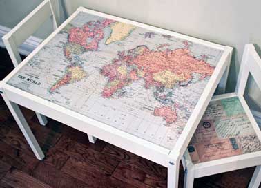 Recouverte d'une carte du monde en papier peint, la table enfant Ikea devient ludique. Les chaises assorties sont relookées avec du papier peint carte postale