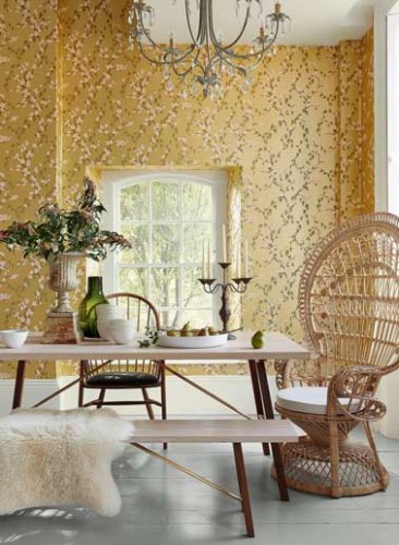 Ton délicat sur les murs et look scandinave dans la salle a manger. Déco avec chaise en rotin, table, banc clair et peau. Sakura papier peint Little Greene.