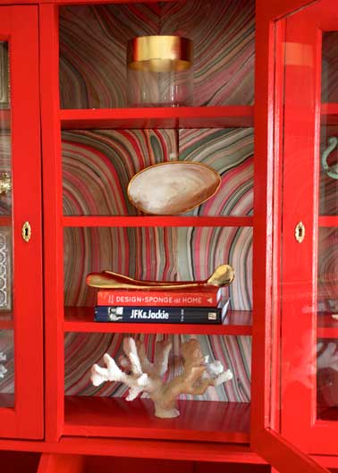 Relooker l'intérieur du vaisselier en bois avec du papier peint coloré. Pour lui donner plus de cachet peignez avec une couleur rouge brillante l'extérieur.