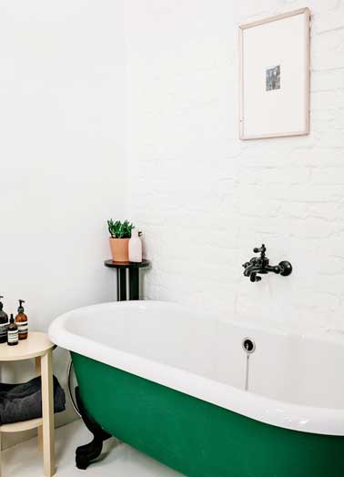 Une couleur de baignoire verte plante le décor de cette salle de bain. Une bonne idée à reprendre comme déco forte pour habiller une petite pièce monochrome