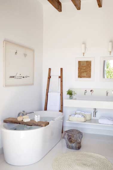 Le bois donne une couleur authentique dans cette petite salle de bain blanche. L'unité entre sol et plafond apportent du souffle à la pièce et installe une déco zen