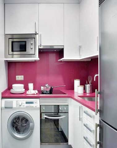 Crédence en résine fushia coordonnée au plan de travail en L dans cette petite cuisine. Brillance et couleur de la crédence apportent profondeur à la cuisine.