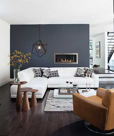Peinture gris anthracite sur un pan de mur du salon en opposition à la peinture couvrante blanche. Canapé d'angle blanc, parquet en bois pour déco cocooning