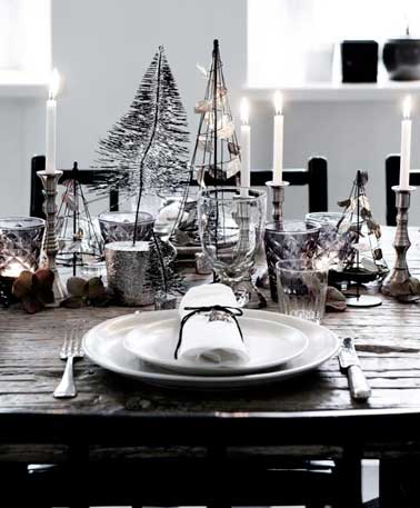 Tendance bohème chic sur cette table de Noël à la déco précieuse. Vaisselle blanche, couverts argent et sapins en métal coloré sophistiquent ce décor noir.