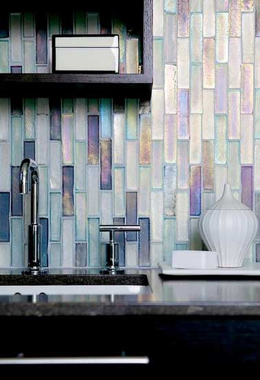 Crédence en mosaïque de verre transparente blanc irisé. En accord avec le plan de travail en marbre gris qui fait un beau contraste avec l’étagère en bois noir