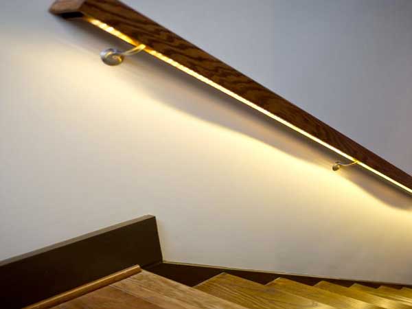 Un éclairage led posé sous la rampe de la cage d’escalier donne de la lumière aux escaliers en bois et leur apporte une douce ambiance tamisée. 