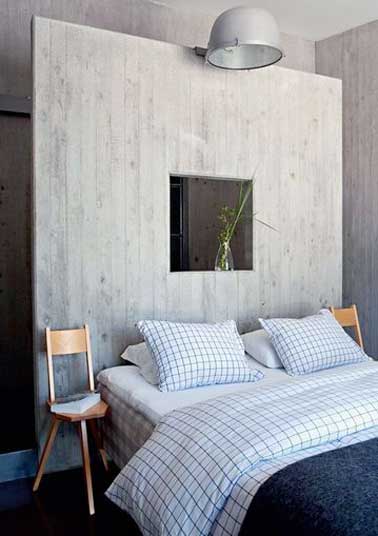 Dans cette suite parentale une cloison tête de lit fait la séparation entre la chambre et la salle de bain. Réalisée en bois blanchi pour une déco naturelle