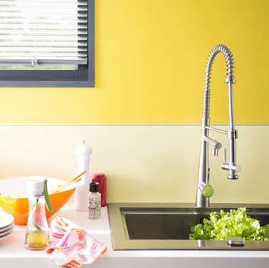 Une peinture jaune apporte toute son énergie sur la crédence de cette cuisine moderne. Peint avec deux couleurs assorties. Peinture sorbet citron satin, Dulux