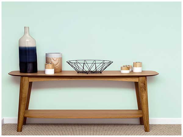 Une couleur pastel vert d'eau habille le mur de l'entrée. Une peinture chaleureuse et douce en harmonie parfaite avec la console en bois style scandinave.