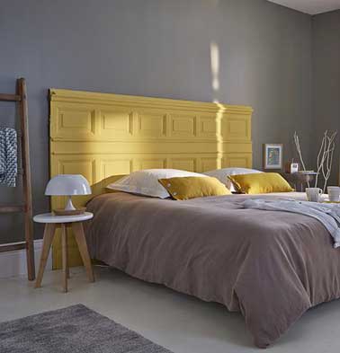 Déco récup pour cette tête de lit réalisée avec un soubassement. Repeint dans une couleur de peinture jaune, elle amène modernité et caractère à la chambre