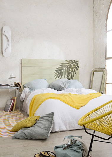 Une déco d'inspiration végétale dans cette jolie chambre grâce à des planches de bois de récup, peintes et fixées au mur pour une tête de lit très originale 