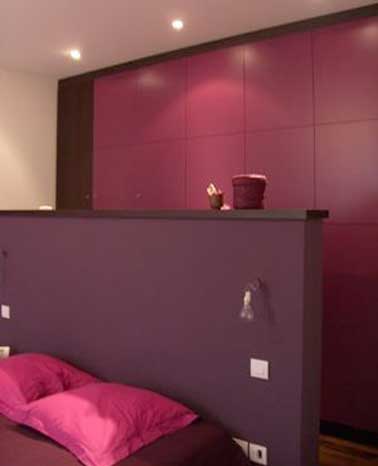 Tête de de lit cloison avec branchements électriques faite en carreaux de plâtres. Avec sa peinture prune, elle s’accorde avec le dressing de la chambre et libère de la place