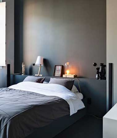 Pratique et design la tête de lit spéciale petite chambre à fabriquer avec un coffrage bois. Ici assortie aux murs gris anthracite elle sert de chevet et de console. 