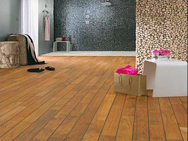 Dans la grande salle de bain le parquet en teck brun foncé met en valeur la douche italienne en carreaux de mosaïque noir et s’accorde avec la déco nature.