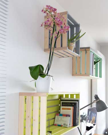 Des caisses en bois repeintes et fixées au mur font des niches de rangements et des étagères pratiques et déco pour le coin bureau. Ici en bois brut verni.